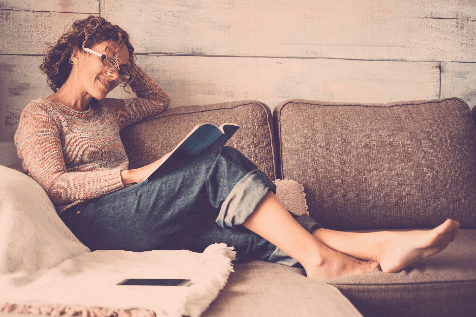 Woman relaxing on sofa reading a book